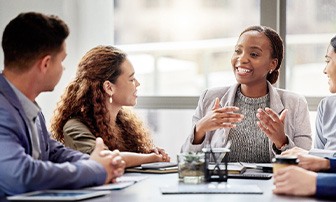 Young woman in meeting talking comfortably with colleagues 