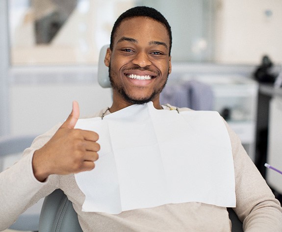 Male dental patient giving a thumbs up