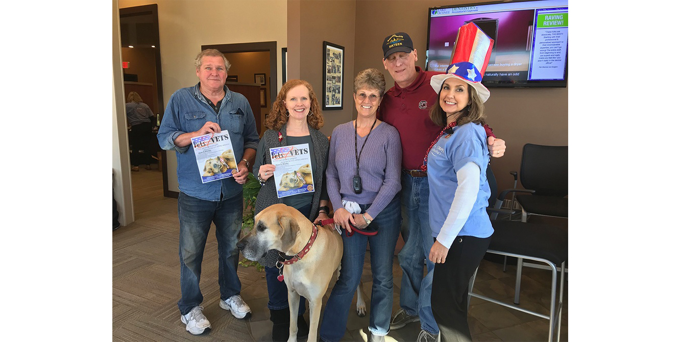 Dentist and team members with dog in the waiting room