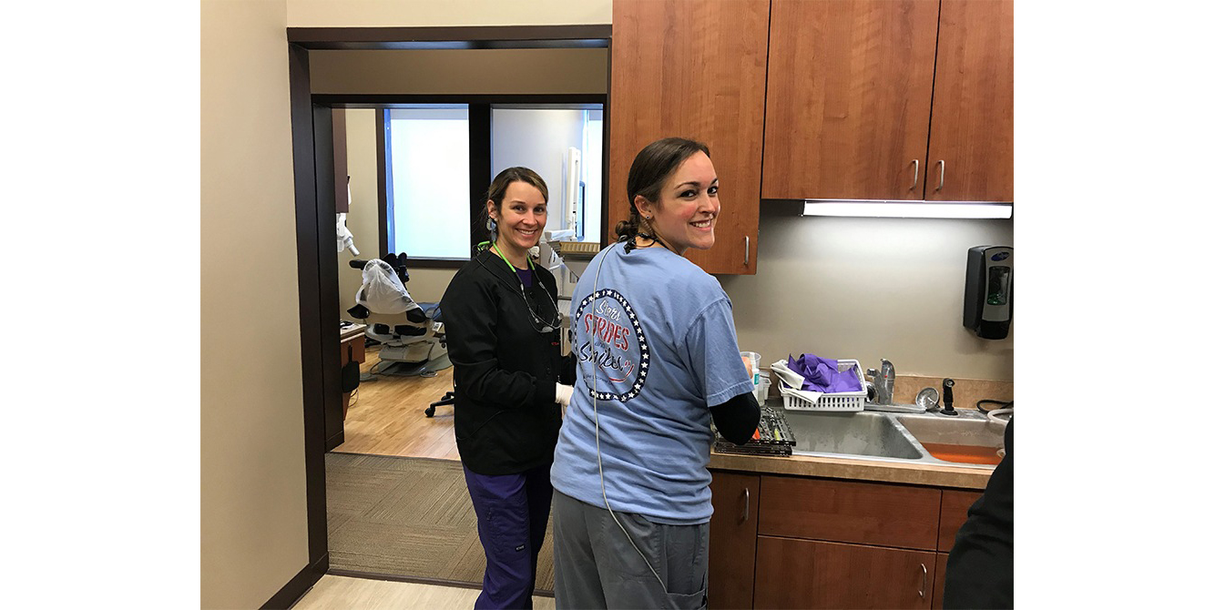 Two dental team members in sanitation area