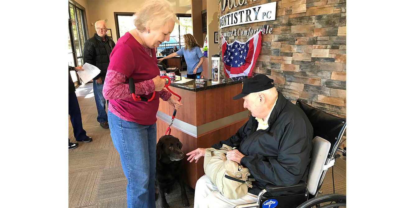 Veteran with dog in dental office waiting room