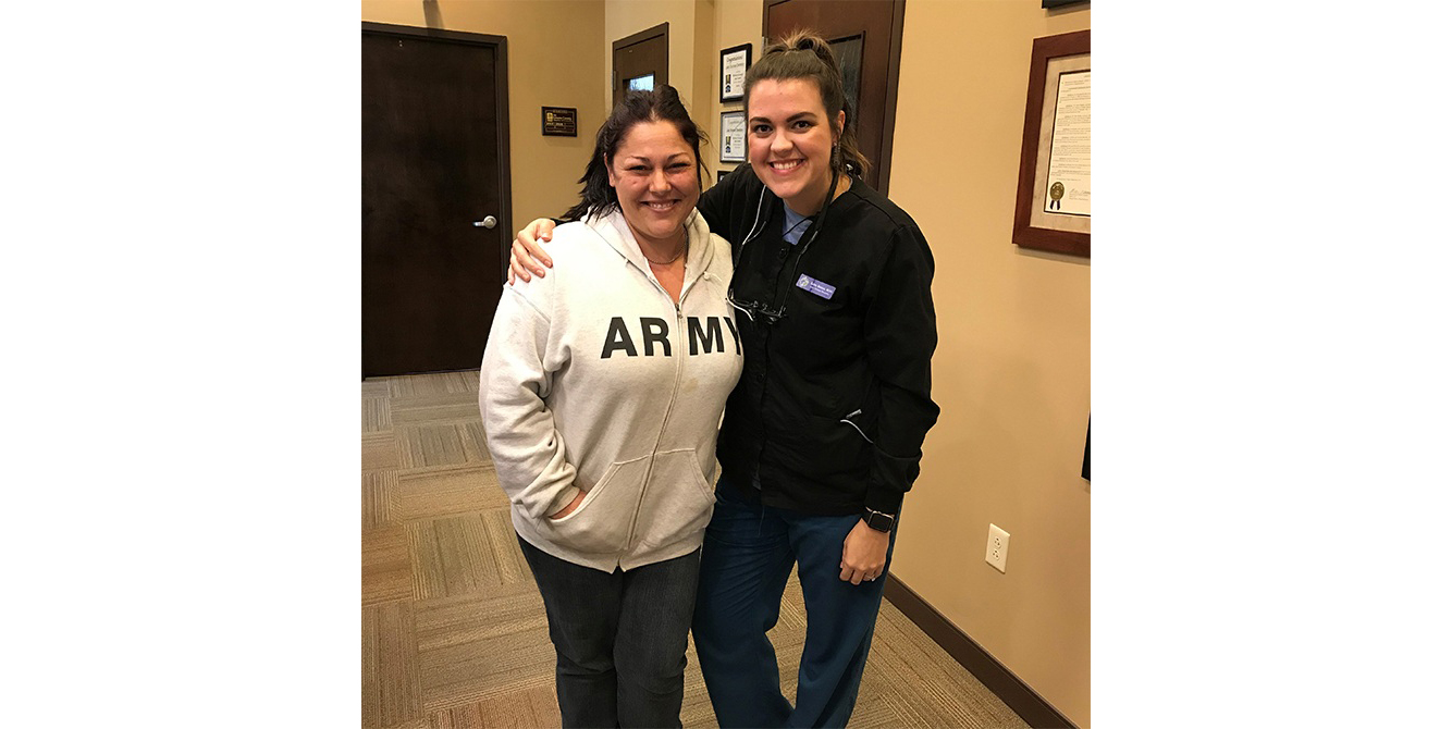 Dental team member and patient smiling together