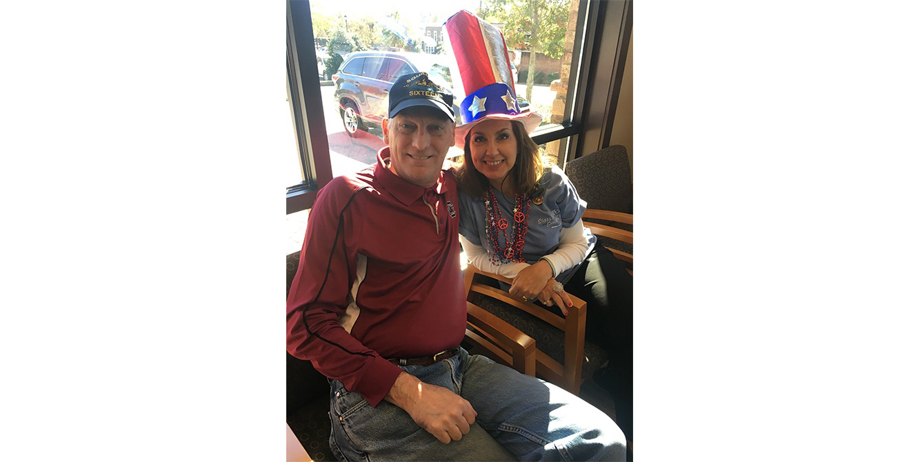 Dental team member and patient smiling in dental office waiting area