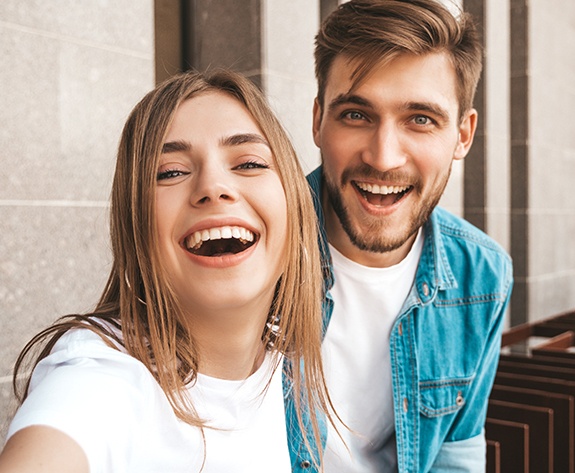 Man and woman sharing flawless smiles after dental bonding