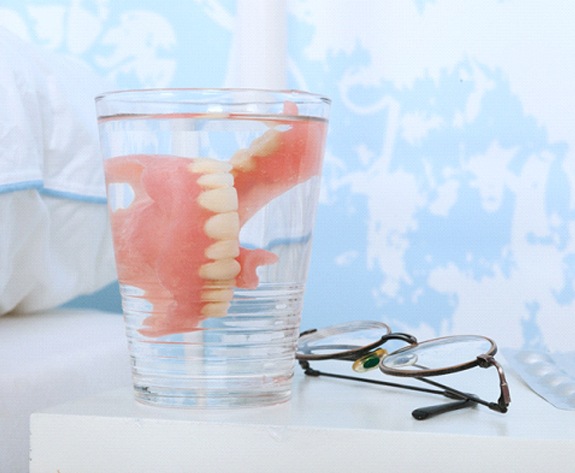 Closeup of dentures in Greensboro in a glass of water