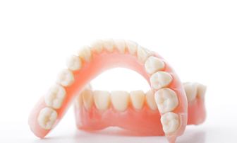 Closeup of full dentures in Greensboro on white background