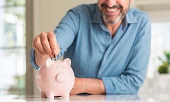 Smiling man saving up for the cost of dental emergencies in Greensboro