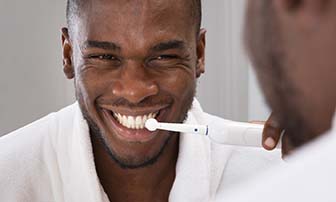Man brushing his teeth to prevent dental emergencies in Greensboro