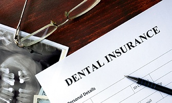 A dental insurance form on a wooden background