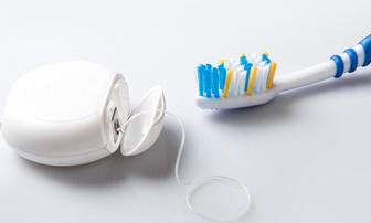 Close up of toothbrush and floss on white background