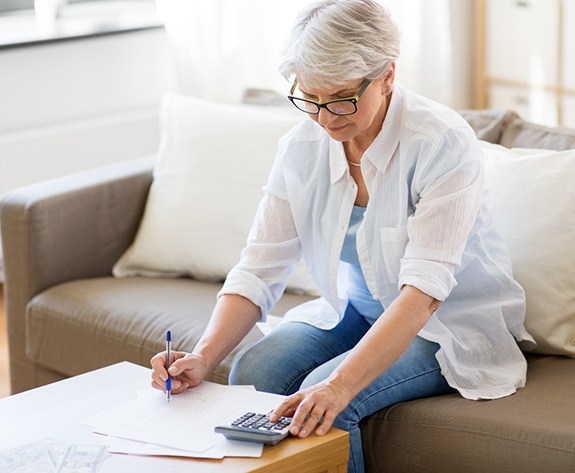 woman calculating the cost of dental implants