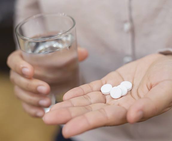 Hand holding oral conscious sedation pills