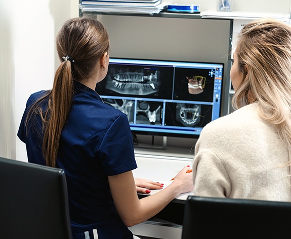 Dental team members looking at digital x-rays