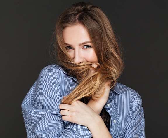 Woman in need of porcelain veneer covering her mouth