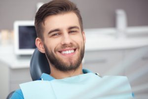 a young man smiling in the dentist chair