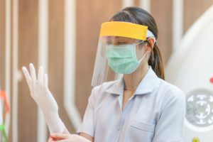 Greensboro dentist dons PPE in preparation for dental appointment